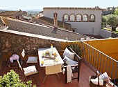 Sunny seating area on terrace with view across Mediterranean roofs
