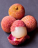 Several lychees, some whole and some cut open
