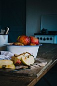 Fresh apples, some sliced, in a rustic kitchen