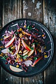 Red cabbage salad with red onion, apple wedges, parsley, sultanas, walnuts and pomegranate seeds