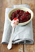 Cranberry jam in a bowl with a spoon
