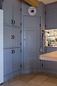 Corner cupboard in country-house-style fitted kitchen with blue-grey fronts