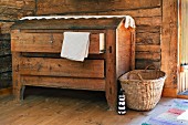 Old wooden trunk with drawers and basket against rustic wooden wall