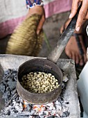 Frau röstet grüne Kaffeebohnen während der traditionellen Kaffeezeremonie in Äthiopien