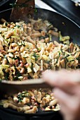 Spaetzle with savoy cabbage, quince and bacon in a pan
