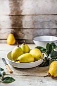 Fresh pears in a bowl on a wooden table