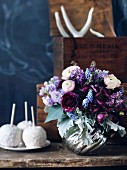Blumenstrauss in silberner Vase auf rustikalem Holztisch
