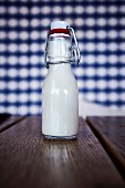 A small bottle of milk on a wooden table