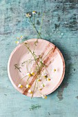 Edible chamomile flowers on plate (top view)