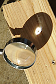Magnifying glass focusing sun light