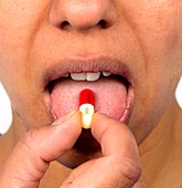Woman taking an antibiotic capsule