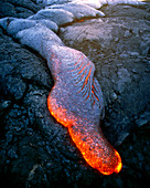 Molten pahoehoe lava flowing across lava plain
