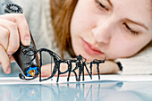 Young woman using 3D printing pen