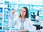 Scientist holding a glass beaker