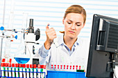 Female chemist using pipette in lab