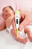 Parent taking newborn baby's temperature