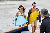 Young couple on beach with surfboards