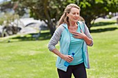 Senior woman holding chest in pain