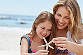 Mother with daughter holding a starfish