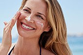 Woman applying sun cream to face