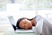 Young woman asleep on laptop