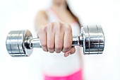 Young woman holding dumbbell,close-up