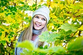 Young woman surrounded by autumn leaves