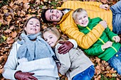 Family lying on dried leaves