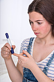 Teenage girl doing a finger prick test