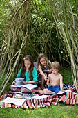 Children playing in a den outside