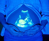 Pregnant woman with baby scan on tummy