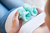 Pregnant woman holding baby booties