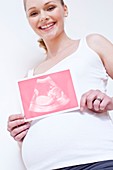 Pregnant woman holding pink baby scan