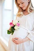 Pregnant woman holding posy of flowers