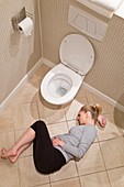 Pregnant woman lying on bathroom floor