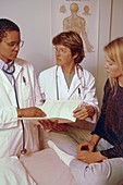 Two doctors consulting with a female patient