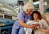 Newborn baby with nurse,mother & incubator