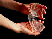Female condom (Femidom) held in a woman's hands