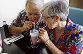 Senior couple shares soda