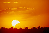 Partial solar eclipse at sunset,July 1990