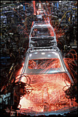 Robot arms welding cars on a production line