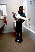 Boy weighing his cat