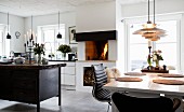 Essbereich, Kamin mit Feuer und Kücheninsel aus alter Werkbank in offener Küche