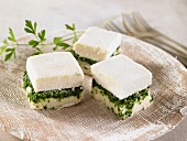 Vegan macadamia nut cheese cubes with spinach and cashew nuts