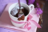 A microwave brownie in a cup decorated with a bow