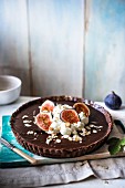 Chocolate tart with cream, fresh figs and almonds