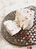 Vegan macadamia nut cheese with red and black peppercorns
