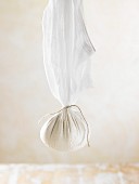 How to prepare vegan macadamia nut cheese: cheese mixture suspended in a muslin cloth to dry