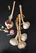 Several bulbs of garlic on a slate surface (seen from above)