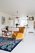 Yellow Baroque armchair on floral rug in front of dining table and kitchen